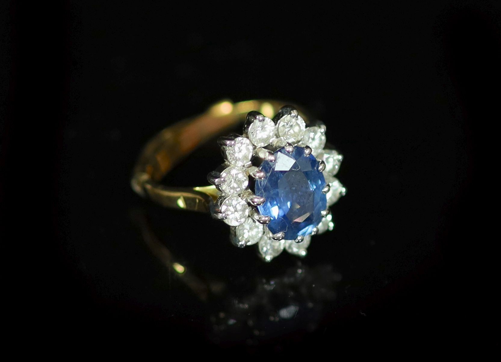 A modern 18ct gold, sapphire and diamond set oval cluster ring